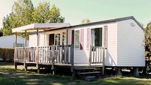 Ein Wohnmobil mit Veranda und einer kleinen Terrasse.