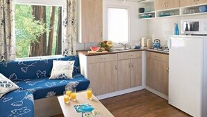 Une cuisine compacte comprenant un coin repas, un four à micro-ondes et un réfrigérateur.