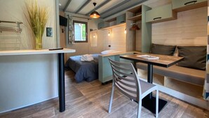 Cocina compacta con comedor, un banco integrado y un ventanal.
