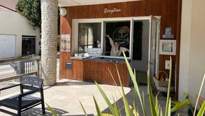 Un área de recepción con fachada de madera, un mostrador de recepción y un letrero que dice 