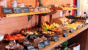Un bufé de desayuno con diversas opciones de comida y etiquetas, en un ambiente de cafetería.