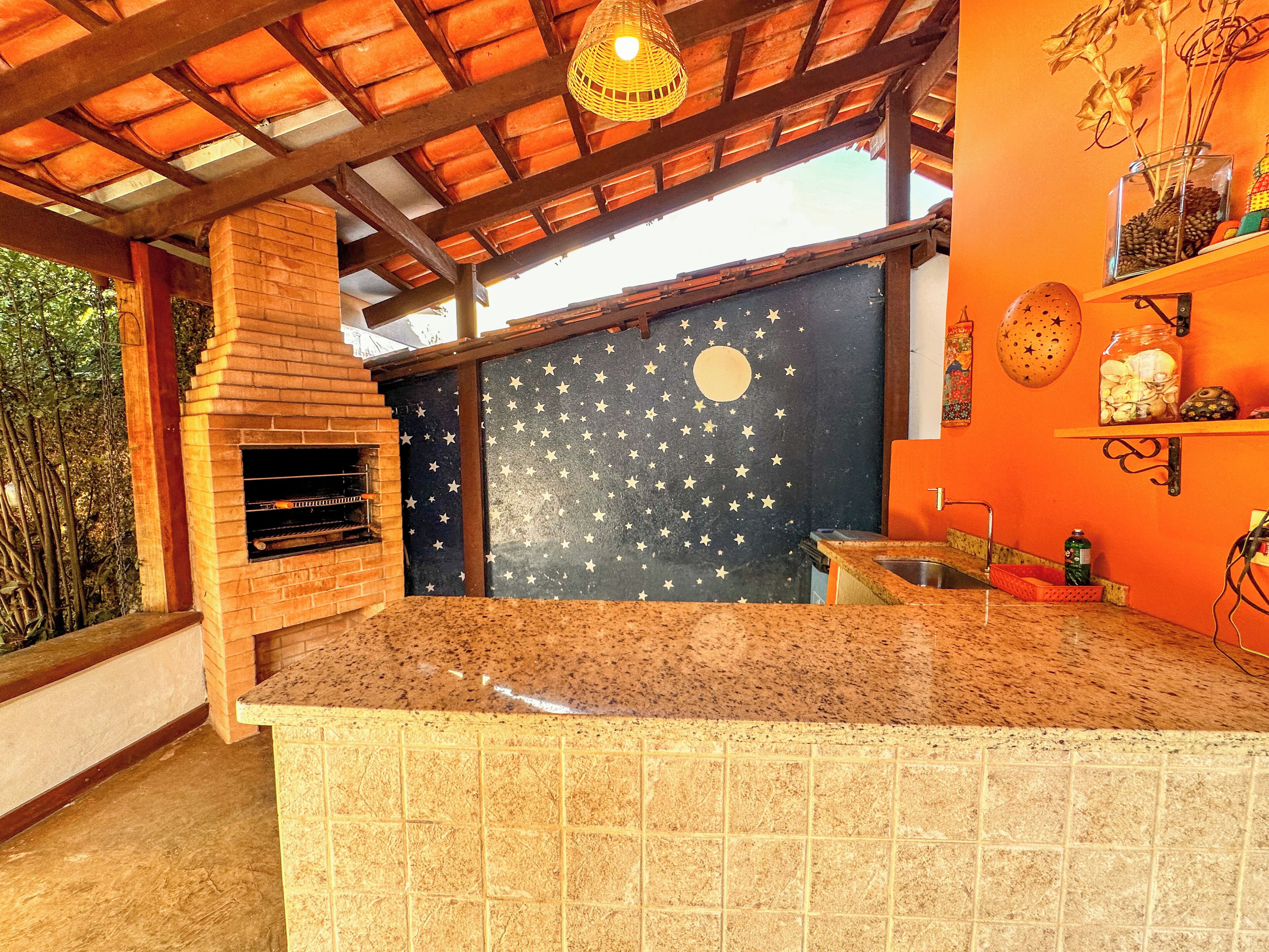 A kitchen with a brick oven, a countertop, and a wall with star and moon decals.