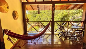 Una hamaca en una habitación de madera con vistas a la vegetación.