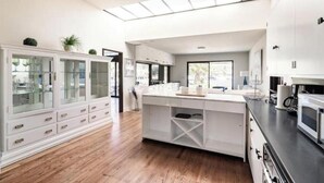 A modern kitchen with white cabinetry, a central island, and a skylight.
