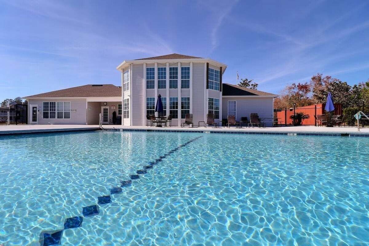Una piscina con acqua cristallina e un edificio con numerose finestre sullo sfondo.
