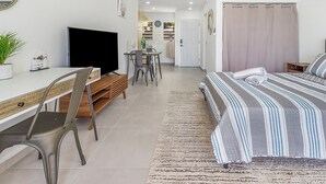 A modern bedroom with a bed, a desk, and a TV. - Newly Renovated apartment with swimming pool and ocean view #3 (Pelican key)