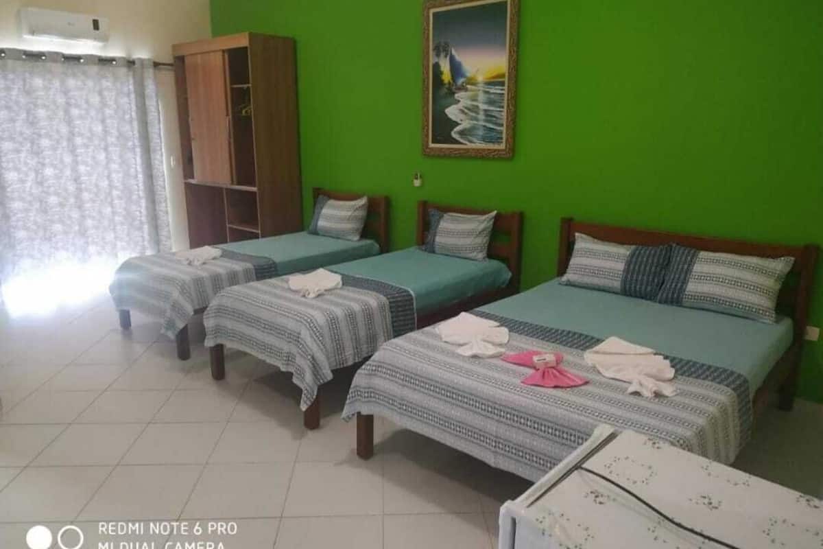 Una habitación con tres camas individuales, un armario y un cuadro en la pared.