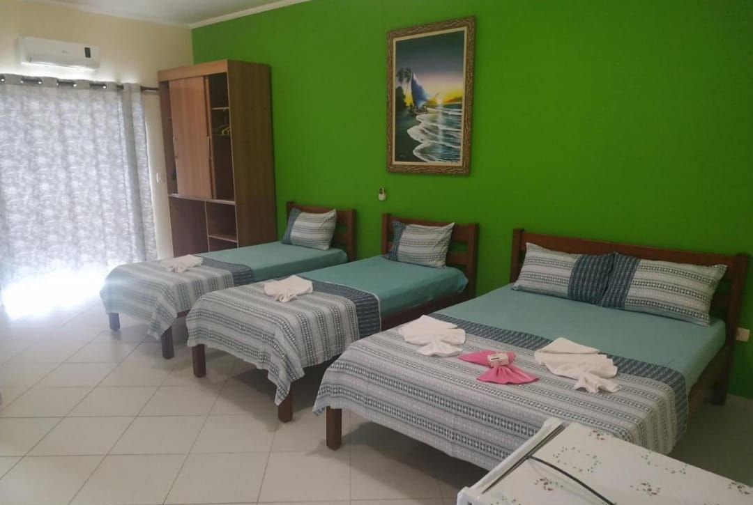 Una habitación con tres camas individuales, un armario y un cuadro en la pared.