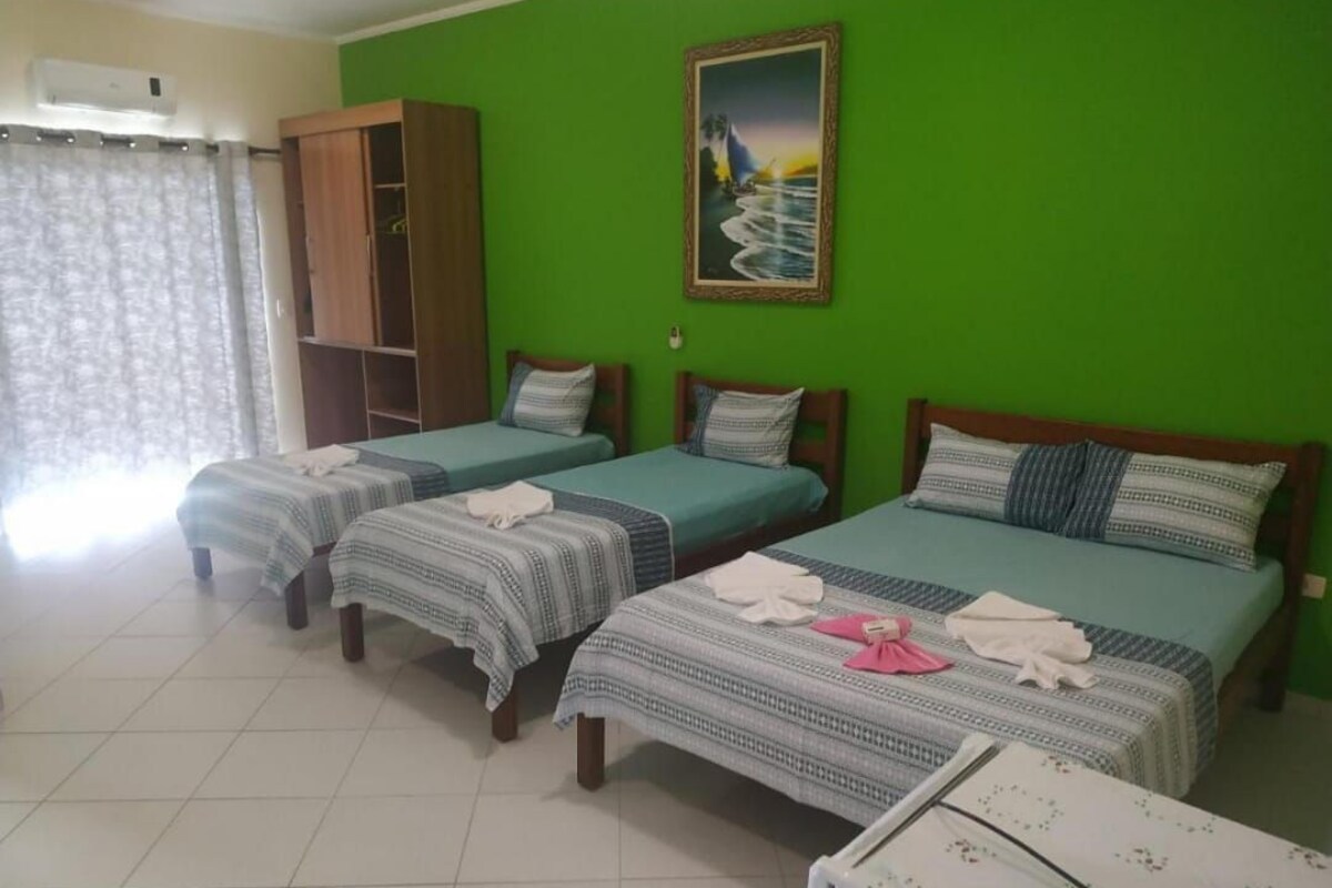 Una habitación con tres camas individuales, un armario y un cuadro en la pared.