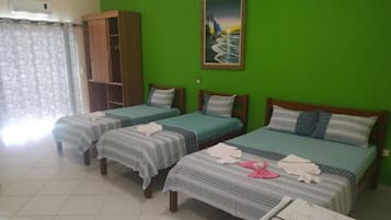 Una habitación con tres camas individuales, un armario y un cuadro en la pared.