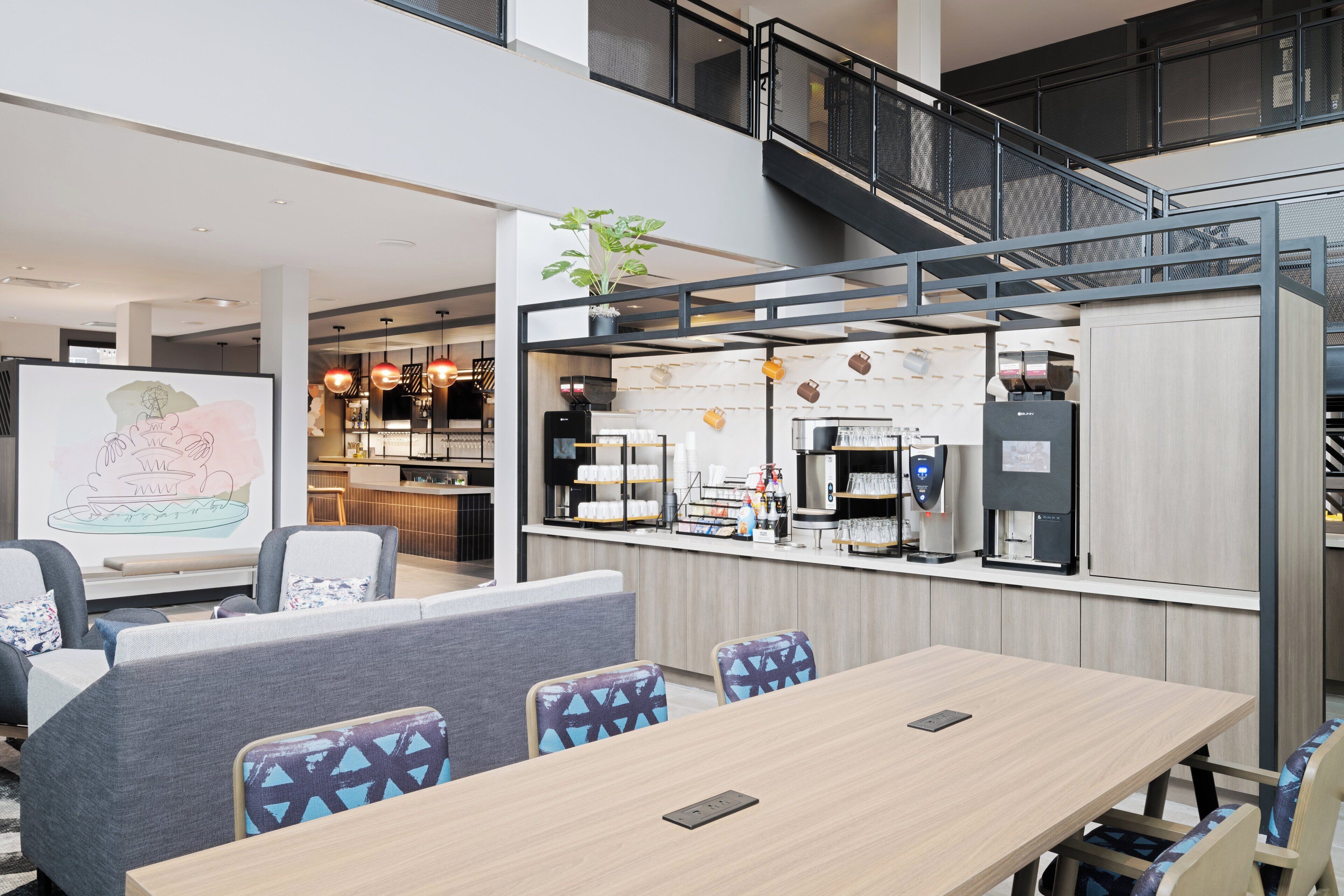 A modern conference room with a long table, several chairs, and a coffee station.