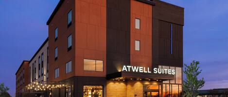 A modern hotel building with a sign reading "ATWELL SUITES."