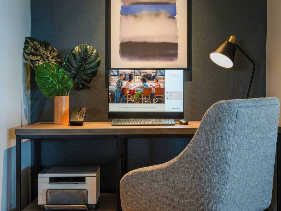 A modern office desk with a computer, a lamp, and a plant.