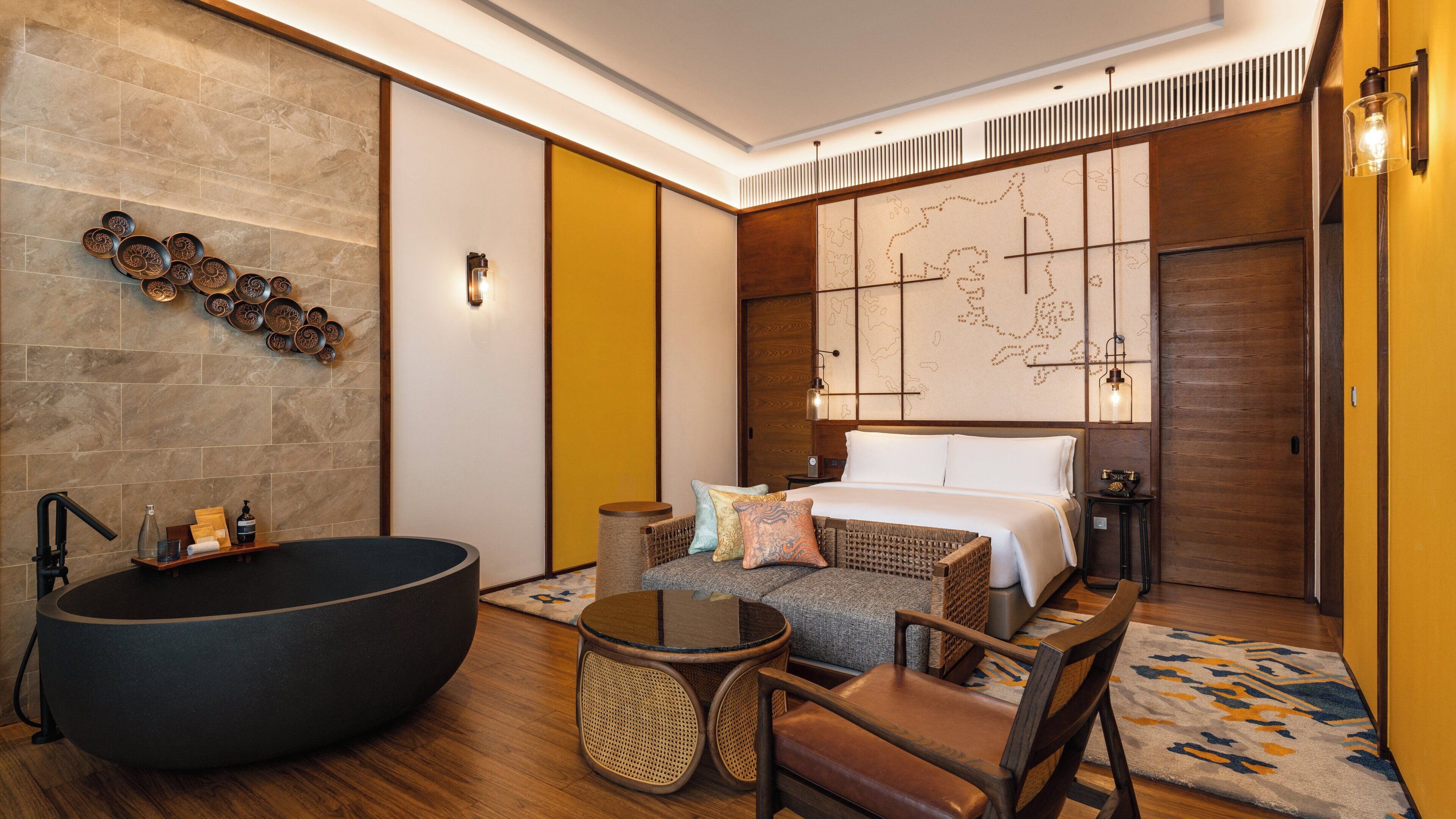Ein modernes Badezimmer mit einer großen Badewanne, Holzboden und einem wandmontierten Waschbecken.