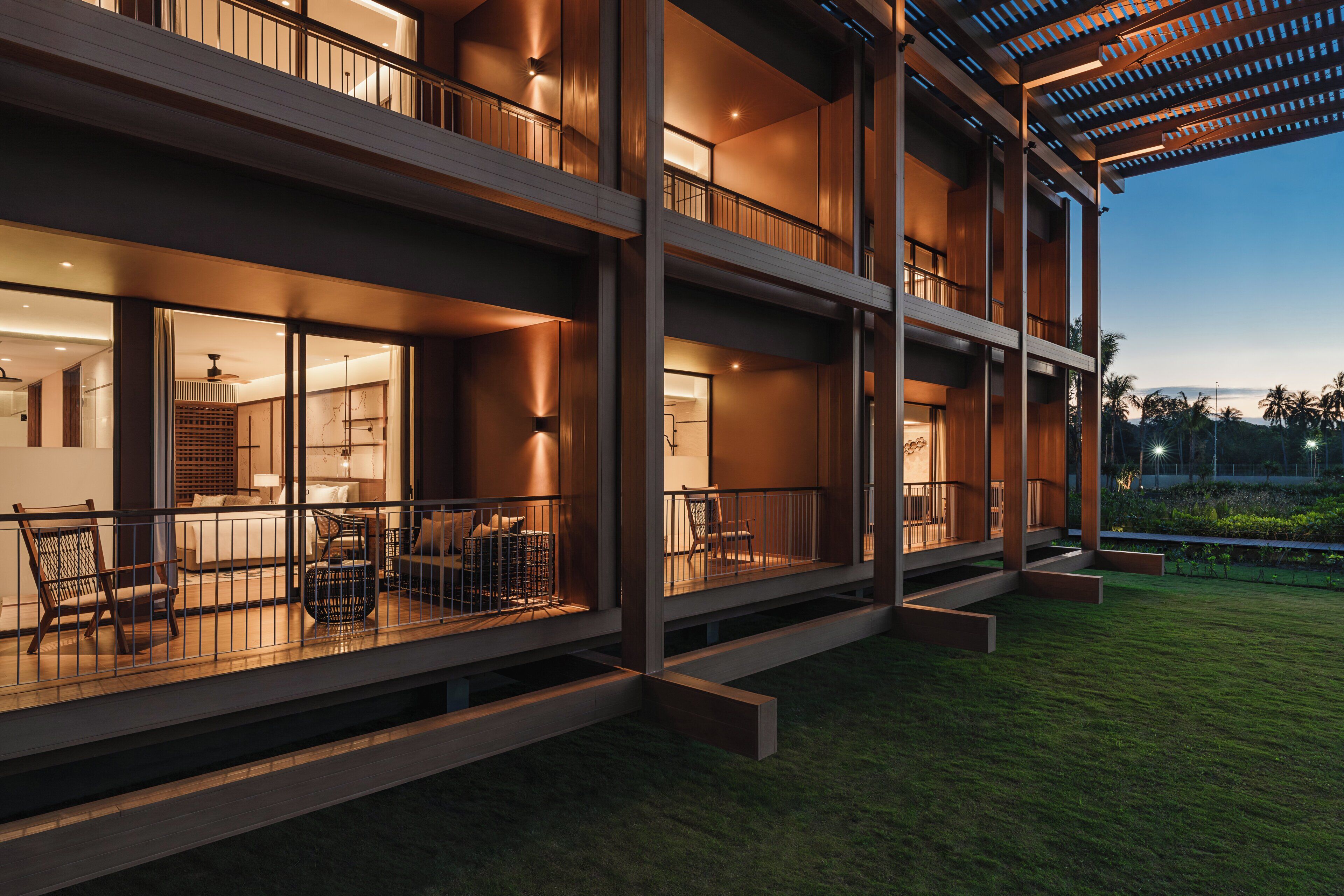 A multi-story building with balconies, outdoor seating, and a well-lit interior.