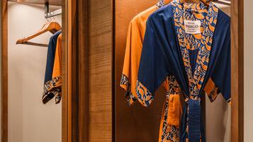 A wooden walk-in closet with a mirror, wooden drawers, and a robe rack.