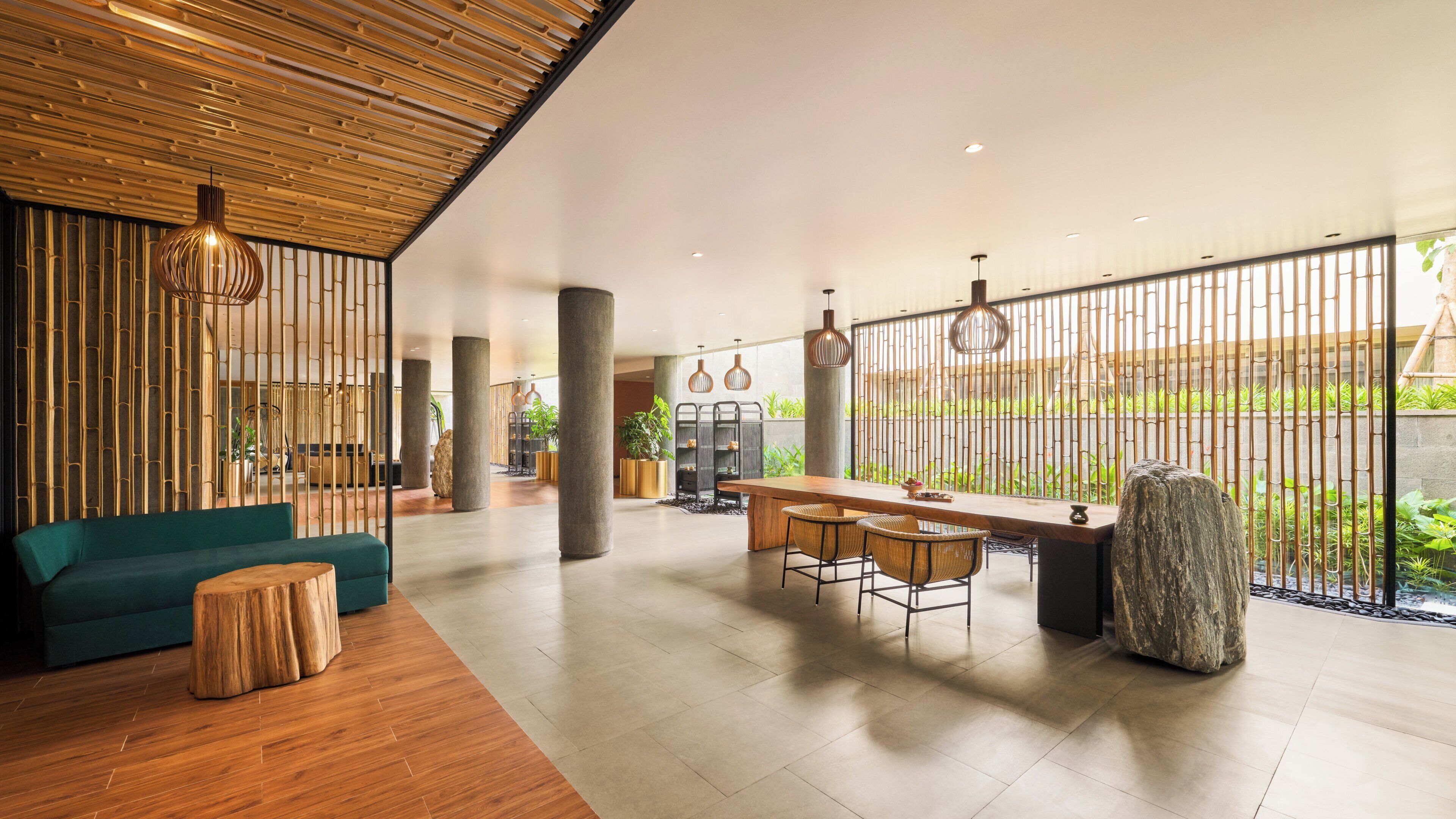A spacious lobby with a wooden ceiling, a seating area with a sofa and chairs, a bar counter, and a view of greenery outside.