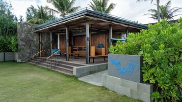 A modern building with a covered entrance, outdoor seating, and a sign reading 'Wavy Waft'.