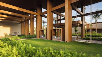Una estructura arquitectónica moderna con grandes vigas de madera, zonas de estar al aire libre e exuberante vegetación.
