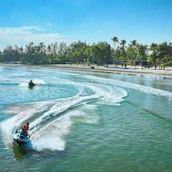 Na praia, areia branca, barracas de praia de cortesia, guarda-sóis