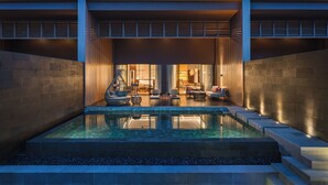 A modern building with a swimming pool, outdoor seating, and a well-lit interior. - Hotel Indigo Bintan Lagoi Beach by IHG (Bintan)
