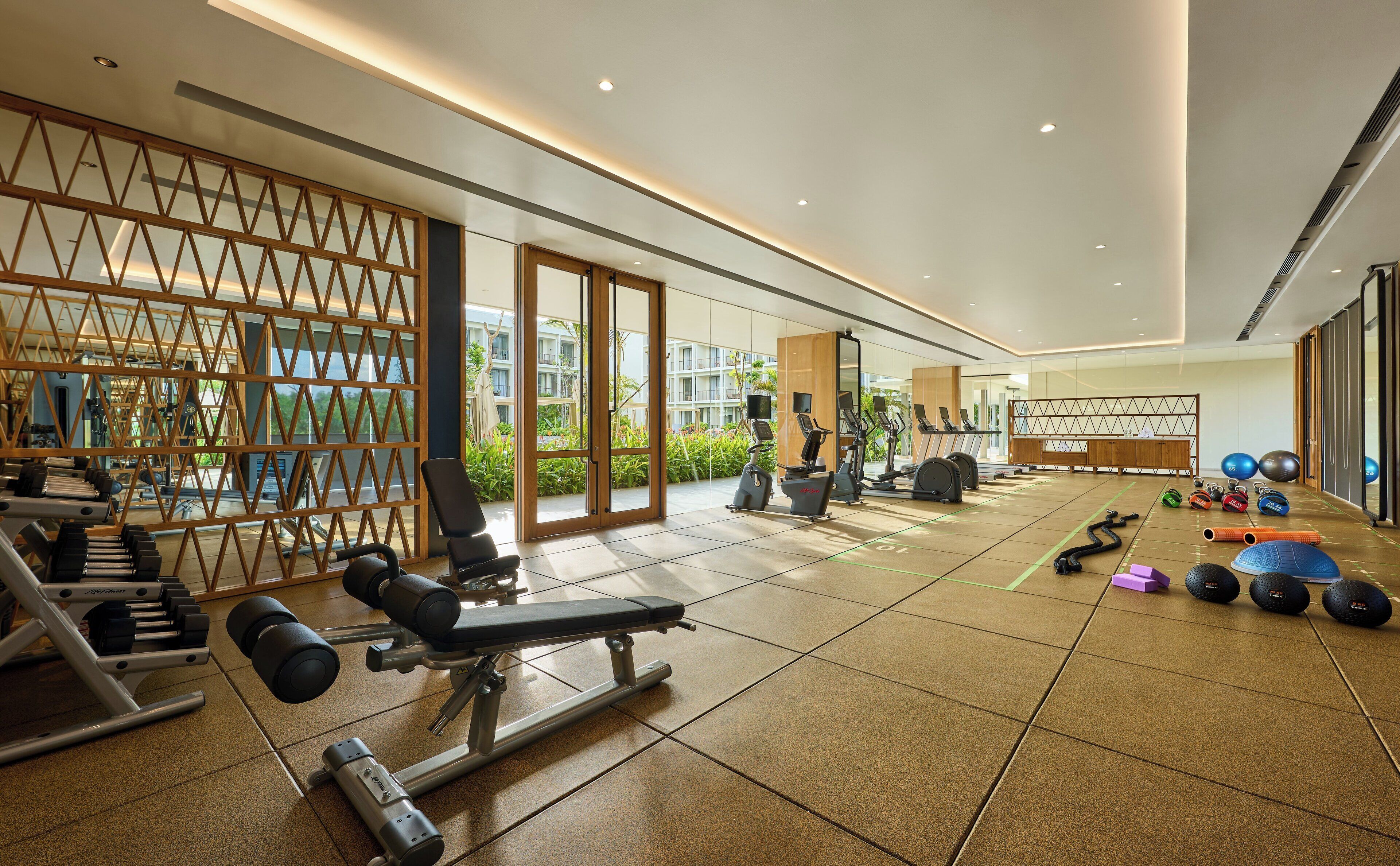 Un gimnasio moderno con equipo cardiovascular, máquinas de pesas y pesas libres.