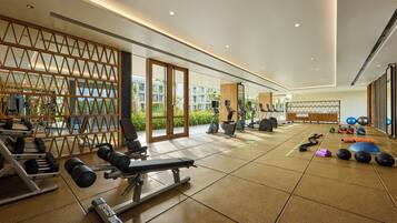 Un gimnasio moderno con equipo cardiovascular, máquinas de pesas y pesas libres.