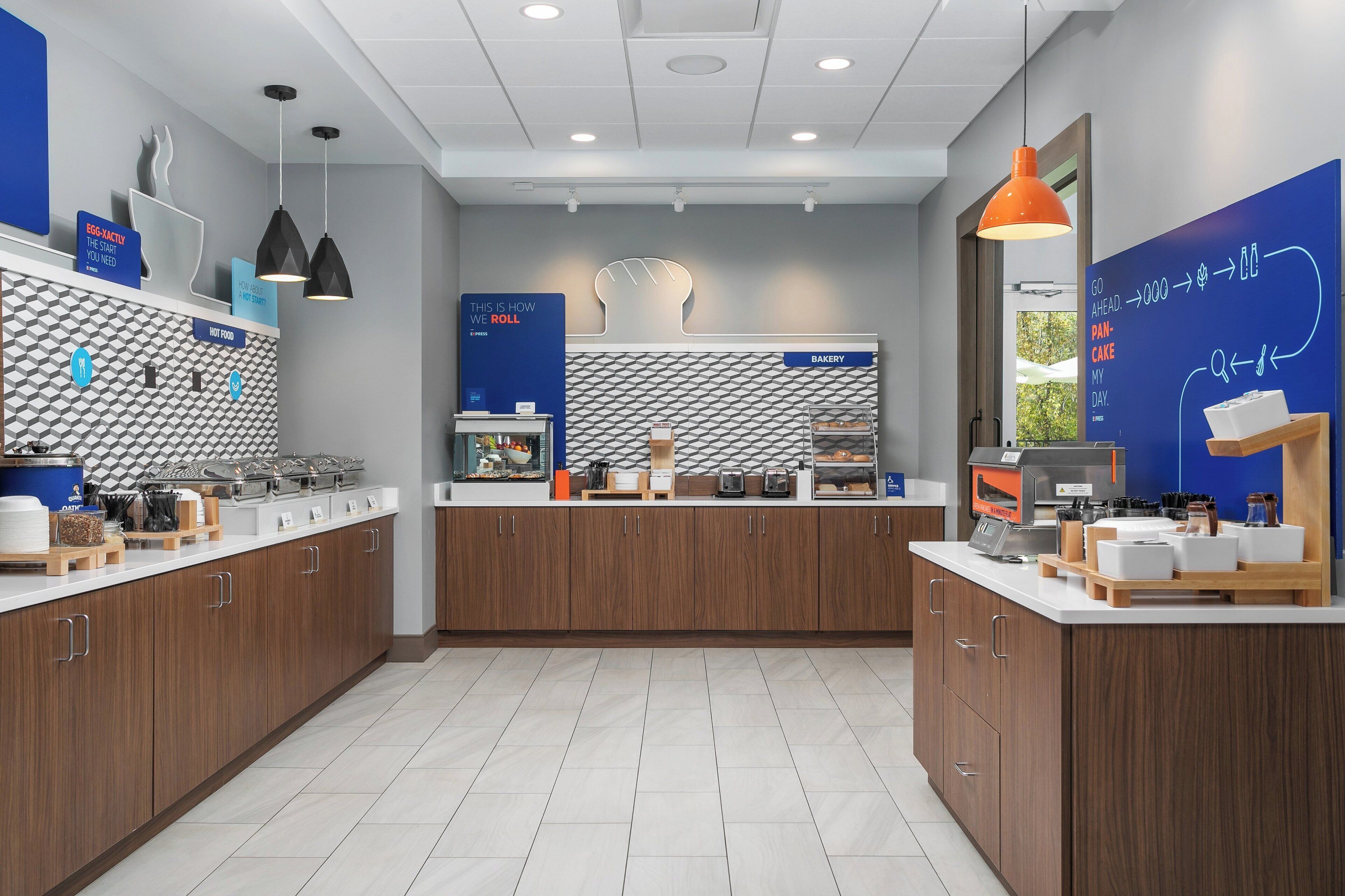 A modern kitchen with wooden cabinets, a central island, and a blue wall with text and graphics.