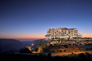 Un hôtel à plusieurs étages, doté d’une architecture moderne, situé sur une falaise surplombant un canyon.