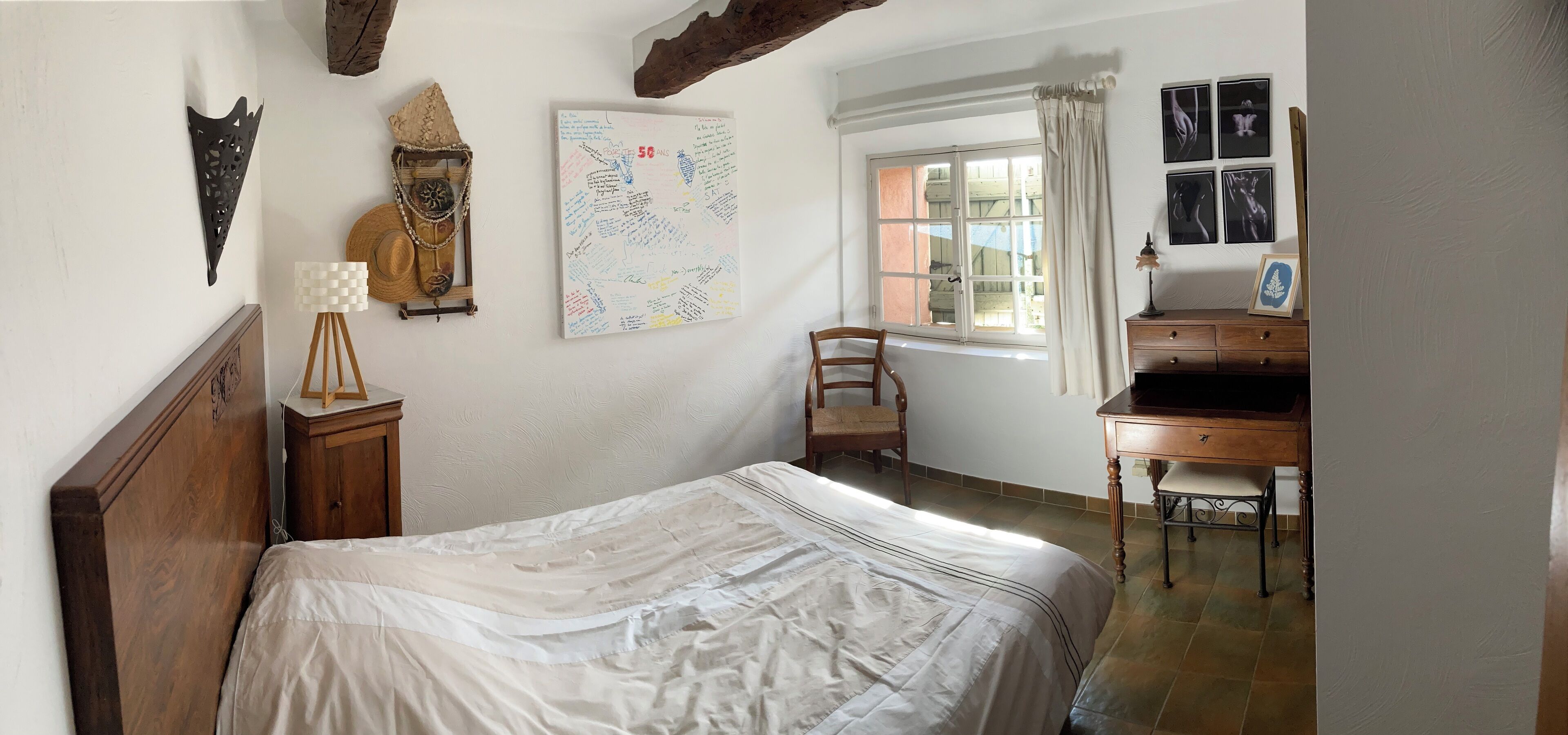Une chambre à coucher comprenant un lit, un bureau, une chaise, une horloge murale et une carte.