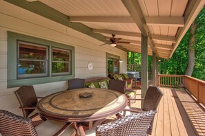 A covered outdoor patio with a round table and wicker chairs, a ceiling fan, and a view of the surrounding greenery. - 1 Sublime View (Deep Gap)