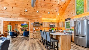 L’intérieur d’une cabane en rondins comprend une cuisine, un coin repas et un salon.