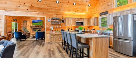 L’intérieur d’une cabane en rondins comprend une cuisine, un coin repas et un salon.