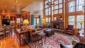 A spacious living room with a fireplace, large windows, and a cozy seating area.