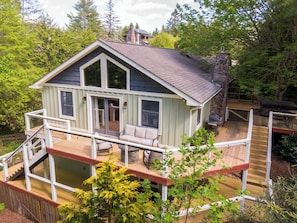A two-story house with a deck, a fireplace, and a covered outdoor seating area. - Bigfoot Bungalow (Blowing Rock)