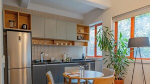 A modern kitchen with a dining area, wooden furniture, and a potted plant. - La Campechana Condesa (Mexico City)
