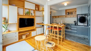 A modern kitchen with grey cabinets, a built-in oven, and a washing machine.