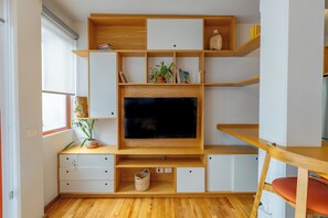 Appartement, 1 grand lit, balcon | Coin séjour | Télévision à écran plat de 50 pouces avec chaînes par satellite