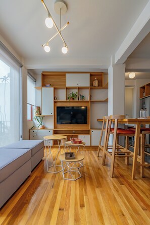 Departamento, 1 cama Queen size, balcón | Área de sala de estar | Televisión de pantalla plana de 50 pulgadas con canales vía satélite
