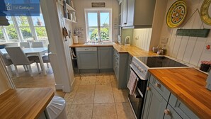 Una cocina compacta con encimera de madera, horno empotrado y ventana con vistas.