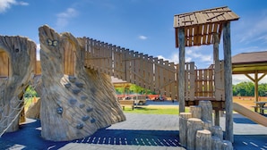 A playground with climbing structures and a wooden bridge.