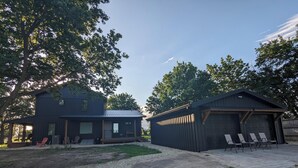 A two-story house with a covered porch and a garage. - New 5- Star Large, Private House, With No Neighbors  (Salina)