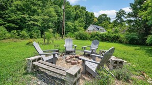 A backyard with a fire pit, Adirondack chairs, and a house in the background. - Cozy 3/1 centrally located in the city.  Perfect for families. Pet friendly! (Charlotte)