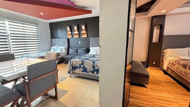 Une chambre d’hôtel moderne, équipée d’un lit, d’un canapé, d’une table à manger et de chaises.