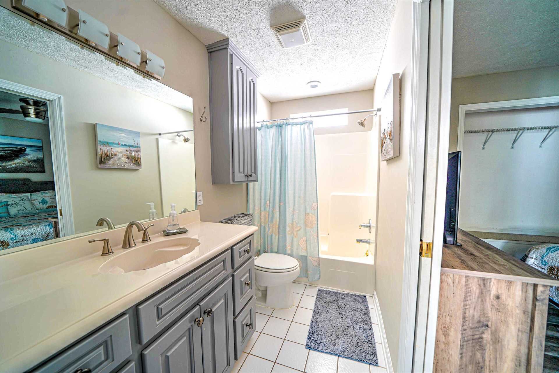 A bathroom with a double sink, toilet, and shower.