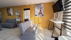 A living room with a sofa, a TV, a table, and a bookshelf. - Departamento Orange 2 Guadalajara (Guadalajara)
