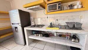 A compact kitchen with a refrigerator, microwave, stove, sink, and various utensils. - Departamento Orange 2 Guadalajara (Guadalajara)