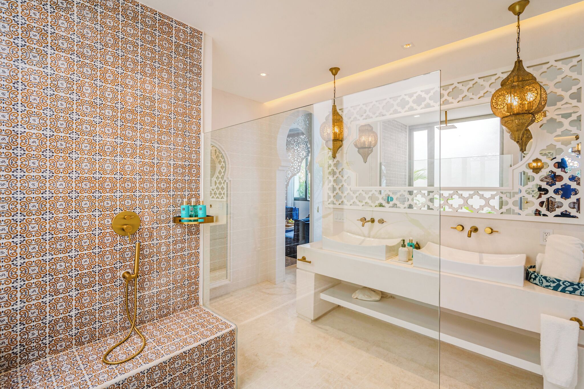 Un baño moderno con pared de azulejos estampados, cabina de ducha a ras de suelo, tocador doble e iluminación decorativa.