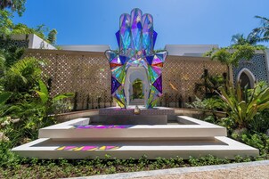 A modern outdoor area with a geometric water feature and a patterned wall.