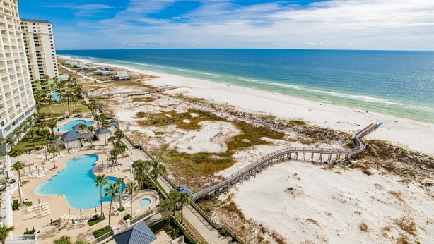 A resort with a beach, a pool, and a pier.